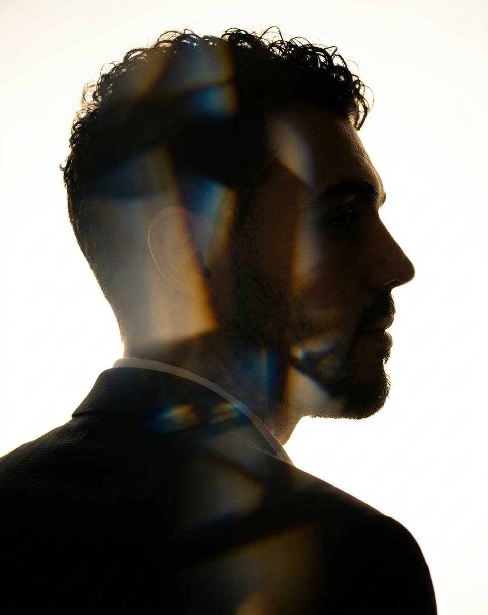 Backlit profile portrait of Silvio Marini, with light flares across the face