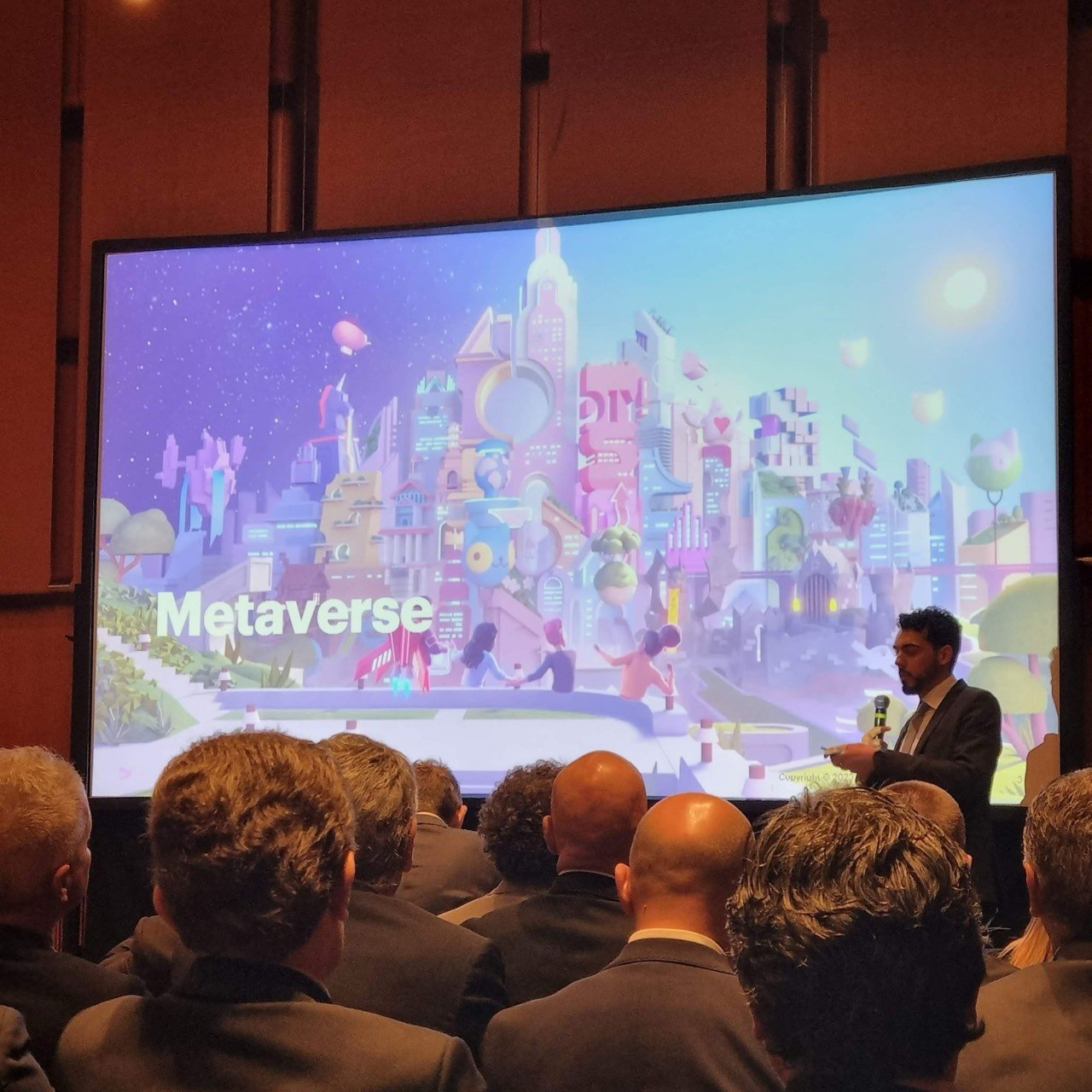 Speaker presenting on the Metaverse to a seated audience